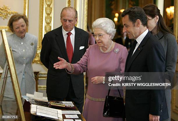 French President Nicolas Sarkozy and his wife Carla Bruni-Sarkozy are shown items from the Royal Collection by Britain's Queen Elizabeth II and...