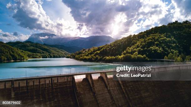 flying above an artificial dam on a lake between mountain range - sweeping landscape stock pictures, royalty-free photos & images