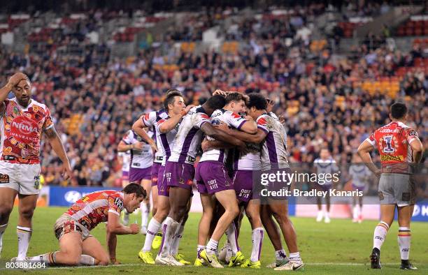 Cameron Smith of the Storm is congratulated by team mates after scoring a try during the round 17 NRL match between the Brisbane Broncos and the...