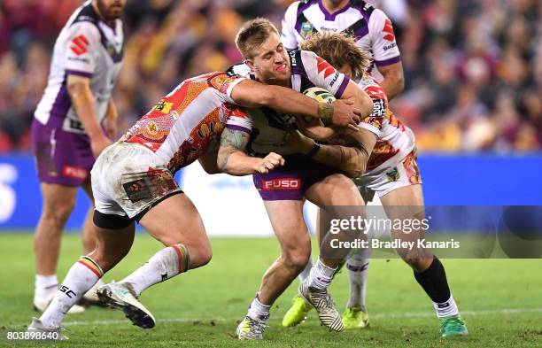 Cameron Munster of the Storm attempts to break away from the defence during the round 17 NRL match between the Brisbane Broncos and the Melbourne...