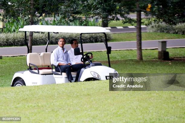 Former U.S. President Barack Obama and Indonesian President Joko Widodo drive a golf cart around Bogor Presidential Palace in Bogor, West Java of...