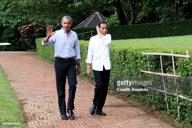 Former U.S. President Barack Obama and Indonesian President Joko Widodo gesture as they walk around Bogor Presidential Palace in Bogor, West Java of...