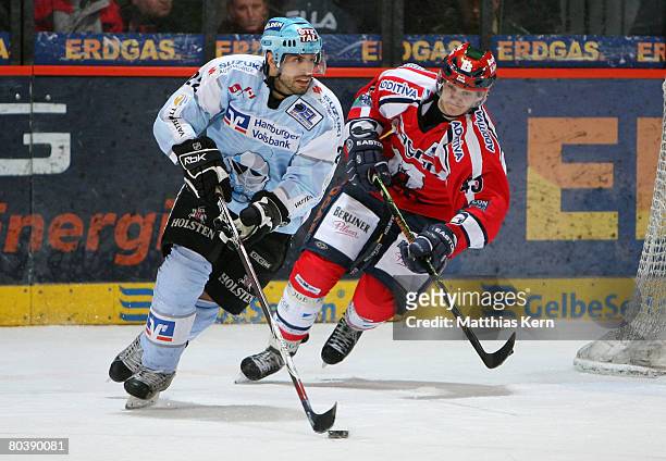 Peter Sarno of Hamburg and Alexander Weiss of Berlin battle for the puck during the DEL Play-Off quarter final match between Eisbaeren Berlin and...