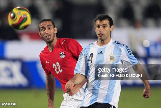 Egyptian player Mohammed Abou Trika vies for the ball with Javier Mascherano of Argentina during their friendly football match in Cairo on March 26,...