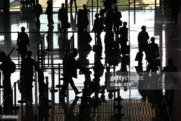 Passengers arrive at the new jumbo Terminal 3 of the Beijing Capital International Airport in Beijing on March 26, 2008. China's air traffic...