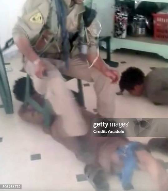 This photo captured from a video shows PYD/PKK members torturing two civilians in Mansoura town western Raqqa, Syria on May, 2017. It is seen in the...