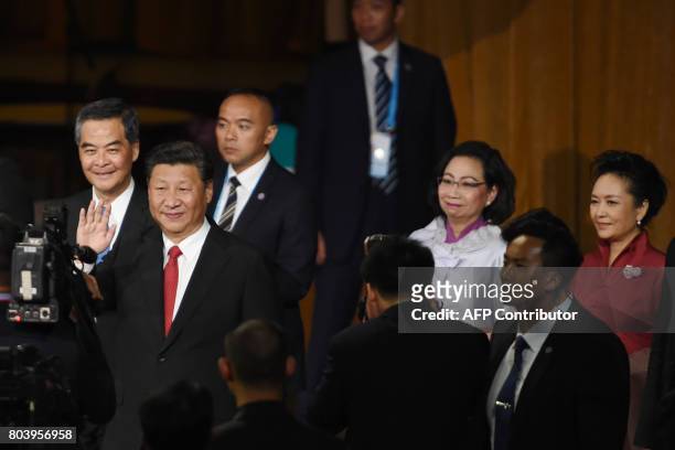 China's President Xi Jinping waves as he arrives with his wife Peng Liyuan while accompanied by Hong Kong's outgoing chief executive Leung Chun-ying...
