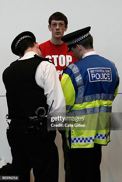 Policemen search a young protestor after a flash mob protest descends upon Terminal 5 International Arrivals on March 27, 2008 in London, England....