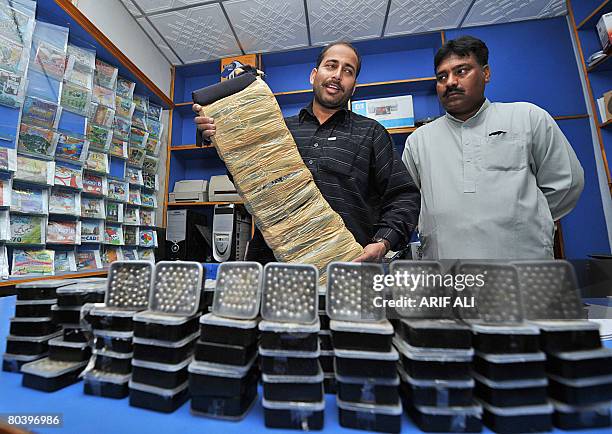 Pakistani policemen show a suicide jacket and explosives recovered from suspected militants in Lahore on March 27, 2008. Pakistani security forces...