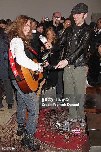 Veteran rocker Patti Smith plays a guitar with her son Jackson during an exhibition called 'Patti Smith, land 250' at the Fondation Cartier on March...
