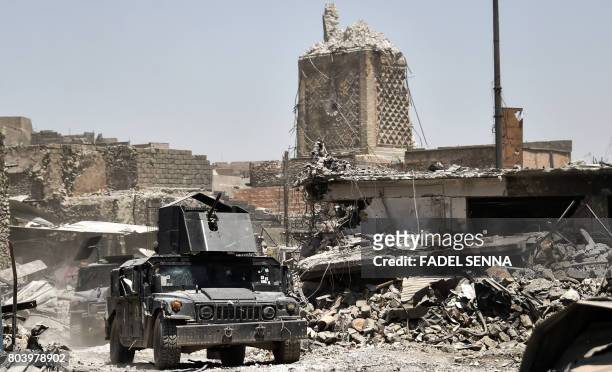 An Iraqi Counter-Terrorism Service humvee passes by the base of Mosul's destroyed ancient leaning minaret, known as the "Hadba" , in the Old City on...