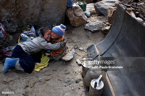 Nepali children play next to a bulldozer while their mothers are busy working on a road widening project March 26, 2008 in Chuzom, Bhutan. Tens of...
