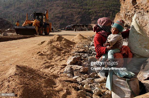 Nepali mother takes care of her child while working on a road widening project March 25, 2008 in Thimphu, Bhutan. Tens of thousands of migrant...