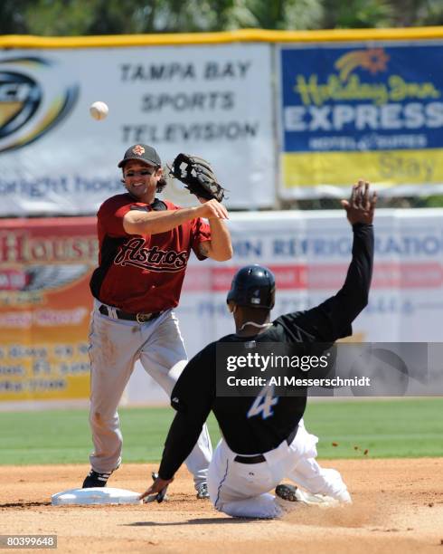 Infielder David Newhan the Houston Astros throws to first base ahead of sliding outfielder Shannon Stewart of the Toronto Blue Jays at Knology Park...