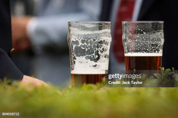 Pints of beer sit on top of a hendge at the Henley Regatta on June 30, 2017 in Henley-on-Thames, England. The five day Henley Royal Regatta is now in...