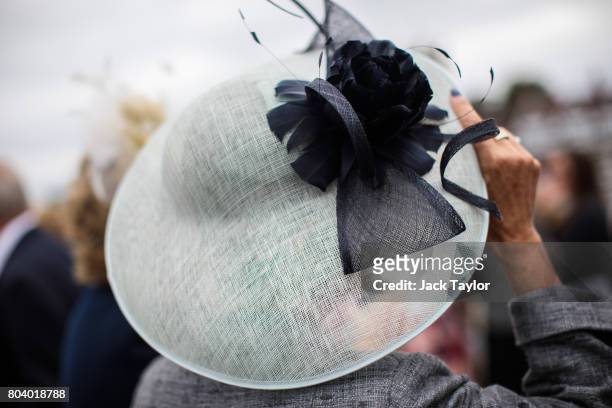 Woman adjusts her hat at the Henley Regatta on June 30, 2017 in Henley-on-Thames, England. The five day Henley Royal Regatta is now in its 178th...