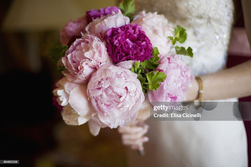 Bride holding bouquet of peony flowers