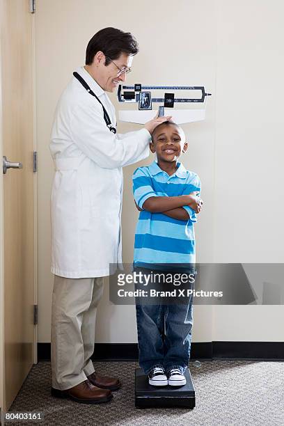 doctor measuring confident boy - brandung bildbanksfoton och bilder