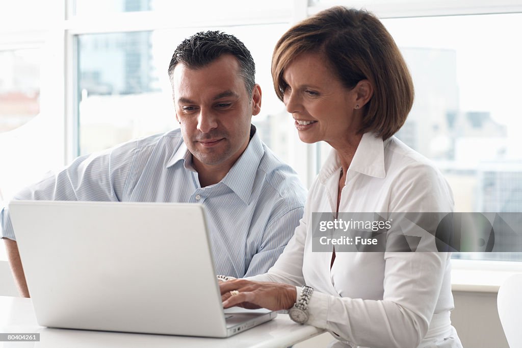 Man and Woman Using Laptop