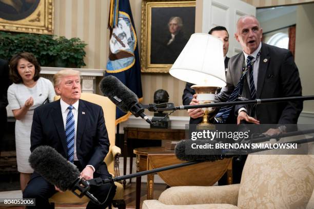 President Donald Trump and Keith Schiller react as a lamp is bumped by press before a meeting with South Korea'ss President Moon Jae-in in the Oval...