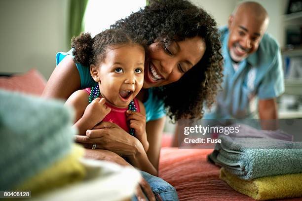 mother and daughter folding laundry - working class mother stock pictures, royalty-free photos & images