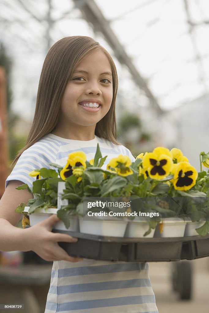 Smiling girl with tray of flowers