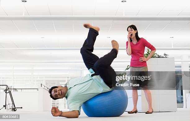 businessman falling off exercise ball - using gym equipment wrong stock pictures, royalty-free photos & images