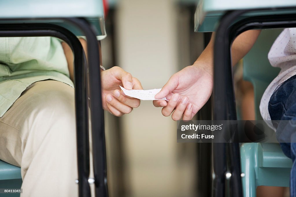 Students Passing Note in Class