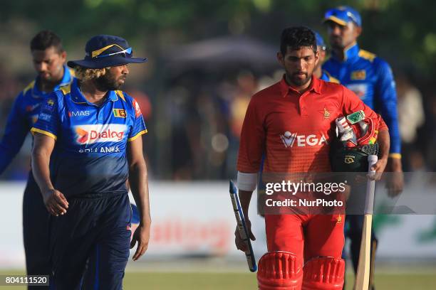 Sri Lankan cricketer Lasith Malinga and Zimbabwe's Sikandar Raza walks back to pavilion after Zimbabwe secured a historic win against Sri Lanka in...
