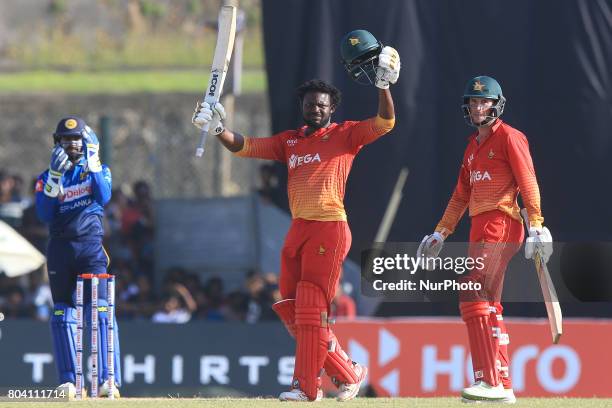 Zimbabwe's Solomon Mire celebrates his maiden century in ODI cricket as his partner Sean Williams looks on during the 1st ODI cricket match at the...