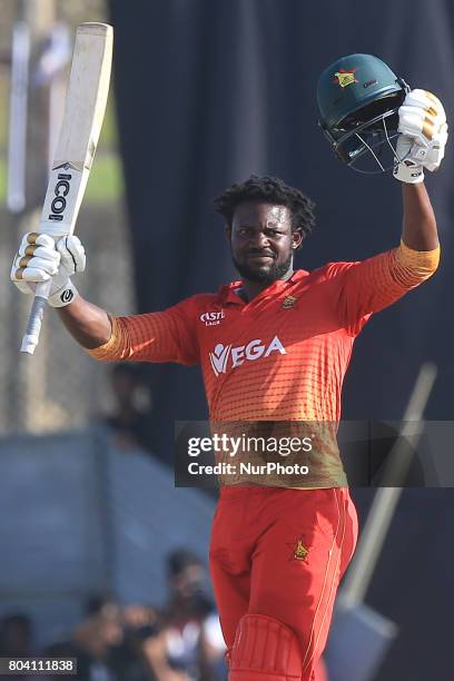 Zimbabwe's Solomon Mire raises his bat after scoring his maiden ODI hundred against the Sri Lankan team in their 1st ODI match at the Galle...