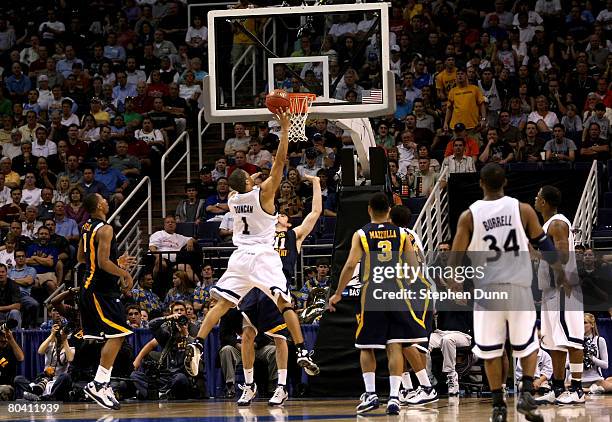 Josh Duncan of the Xavier Musketeers looks for the basket over Jay Alexander of the West Virginia Mountaineers during the second half of the West...