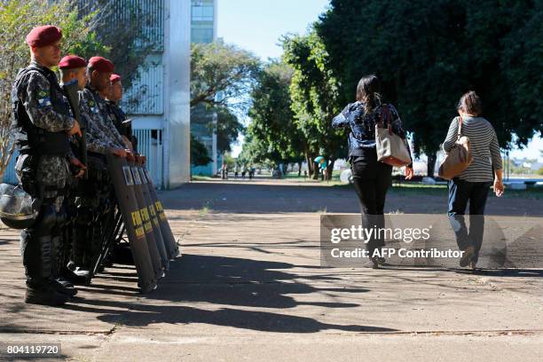 Military policemen reinforce security at the Ministry Esplanade, in Brasilia, on June 30 before a demonstration organized by unions against President...