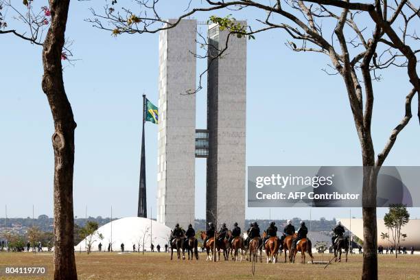 Military policemen reinforce security in front of the National Congress, in Brasilia, on June 30 before a demonstration organized by unions against...