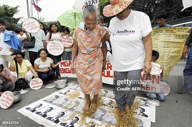 Women farmers perform a traditional threshing of rice stalks during a protest outside the Department of Agriculture office in Quezon city suburban...