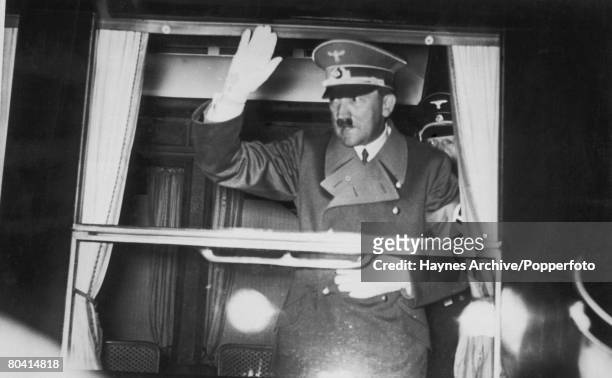 German dictator Adolf Hitler waves from his bullet-proof railway carriage as he leaves Florence for Berlin after a visit to Italian leader Benito...