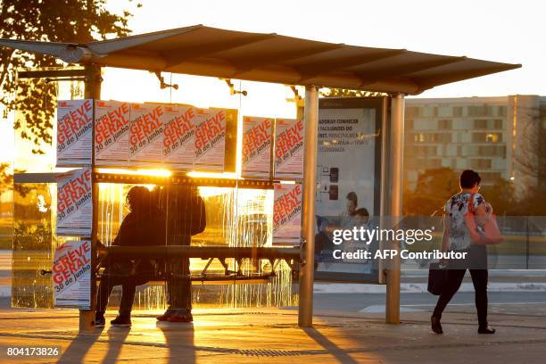 Bus stop in Brasilia is covered in posters calling for a national strike on June 30 before a demonstration organized by unions against President...