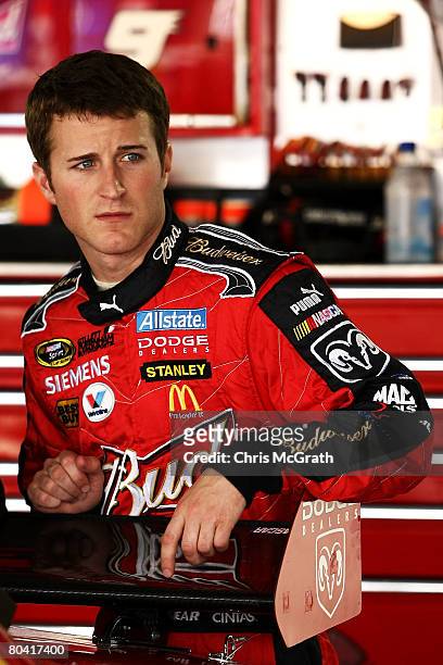 Kasey Kahne, driver of the Budweiser Dodge, stands next to his car in the garage during practice for the NASCAR Sprint Cup Series Goody's Cool Orange...