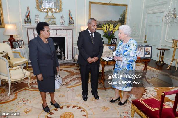 Queen Elizabeth II talks with Sir Robert Dadae the Governor General of Papua New Guinea, and Lady Dadae during a private audience where he was...