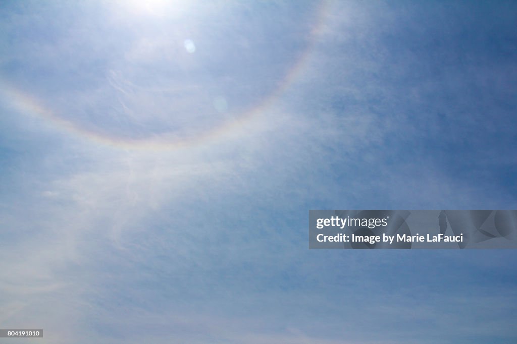 Rainbow halo sun flare in the sky