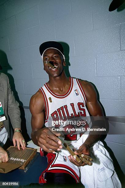 Michael Jordan of the Chicago Bulls celebrates with cigar after winning the 1996 NBA title against the Seattle SuperSonics in Game Six of the 1996...