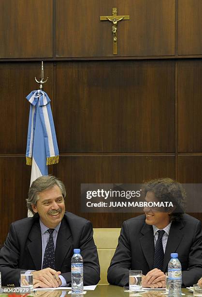 Argentine chief of cabinet Alberto Fernandez and Economy minister Martin Lousteau minister joke during a meeting with members of farmers'...