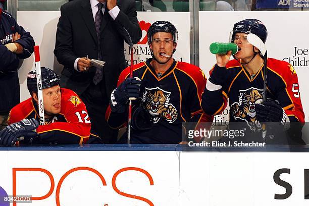 Ollie Jokinen of the Florida Panthers and teammates Brett Mcleean and Kamil Kreps take a break on the bench against the Tampa Bay Lightning at the...