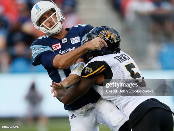 Adrian Tracy of the Hamilton Tiger-Cats puts a hit on Ricky Ray of the Toronto Argonauts during a CFL game at BMO Field on June 25, 2017 in Toronto,...