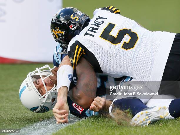 Ricky Ray of the Toronto Argonauts reacts after being hit by Adrian Tracy of the Hamilton Tiger-Cats during a CFL game at BMO Field on June 25, 2017...