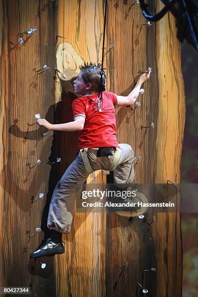 Competitor Maiko Kiesewetter climbs up on dart arrows for a bet during the 175th edition of the 'Wetten, dass...?' TV show presented by German host...