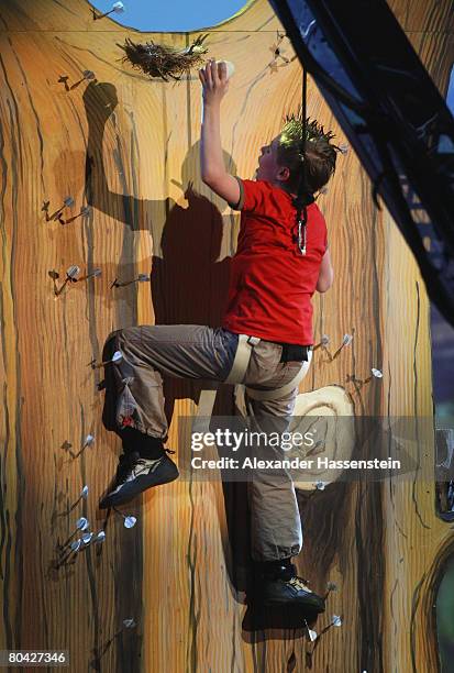 Competitor Maiko Kiesewetter climbs up on dart arrows for a bet during the 175th edition of the 'Wetten, dass...?' TV show presented by German host...