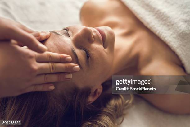 mitte erwachsene frau genießen in ihrem entspannenden kopf-massage im spa. - masseur stock-fotos und bilder