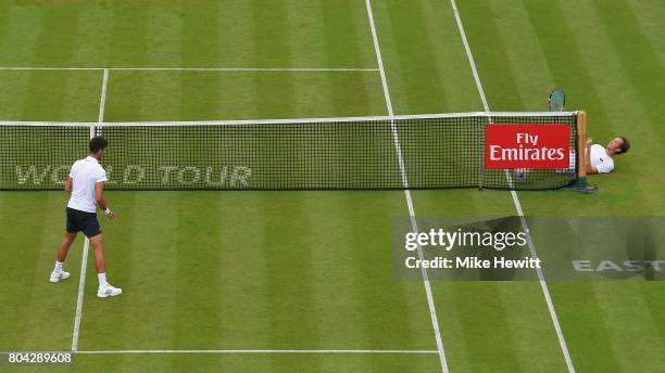 Daniil Medvedev of Russia falls over as Novak Djokovic of Serbia looks on during Day 6 of the Aegon International Eastbourne tournament at Devonshire...