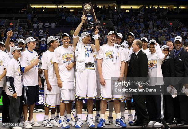 Lorenzo Mata-Rael of the UCLA Bruins hoists the West Regional trophy with his team after they defeated the Xavier Musketeers with the score of 76-57...